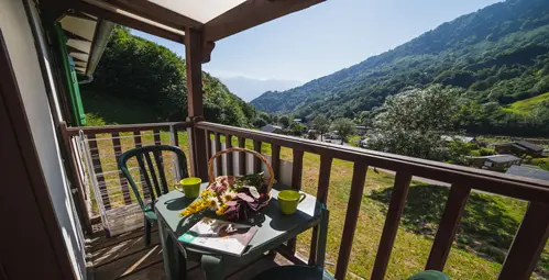 a table on a porch with a view of mountains and trees